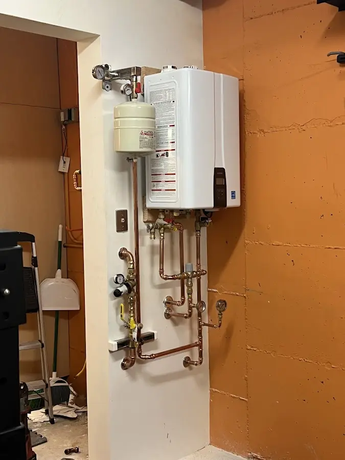 Plumbing technician inspecting water heater connections in Galesburg